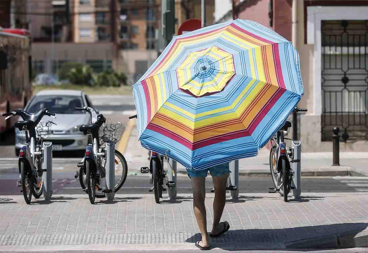 Un hombre con una sombrilla cerca de la Playa de la Malvarrosa, a 12 de agosto de 2022, en Valencia, Comunidad Valenciana (España) / Foto: EP