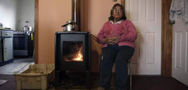 Cristina Calderón, la última hablante del milenario idioma de los yaganes, junto a la lumbre en su domicilio de Villa Ukika / Foto: Alfons Rodríguez