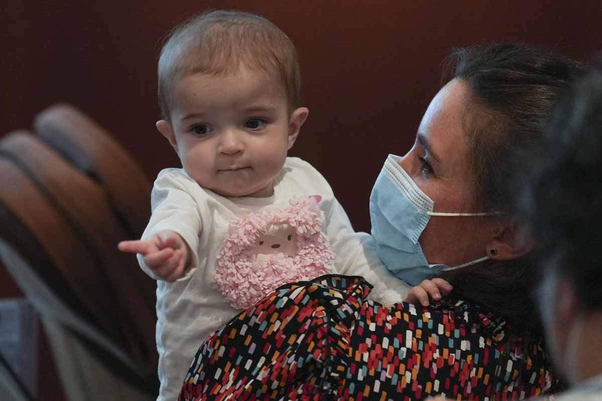 La pequeña Emma, de 13 meses, en brazos de su madre, después del trasplante de intestino realizado con éxito por primera vez en el mundo en el hospital público madrileño de La Paz / Foto: SINC