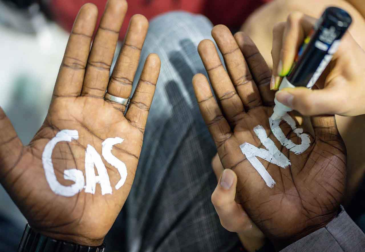 Activista climática del movimiento 'Don't Gas Africa' escribe en las manos 'No al Gas' / Foto: Michael Kappeler - EP