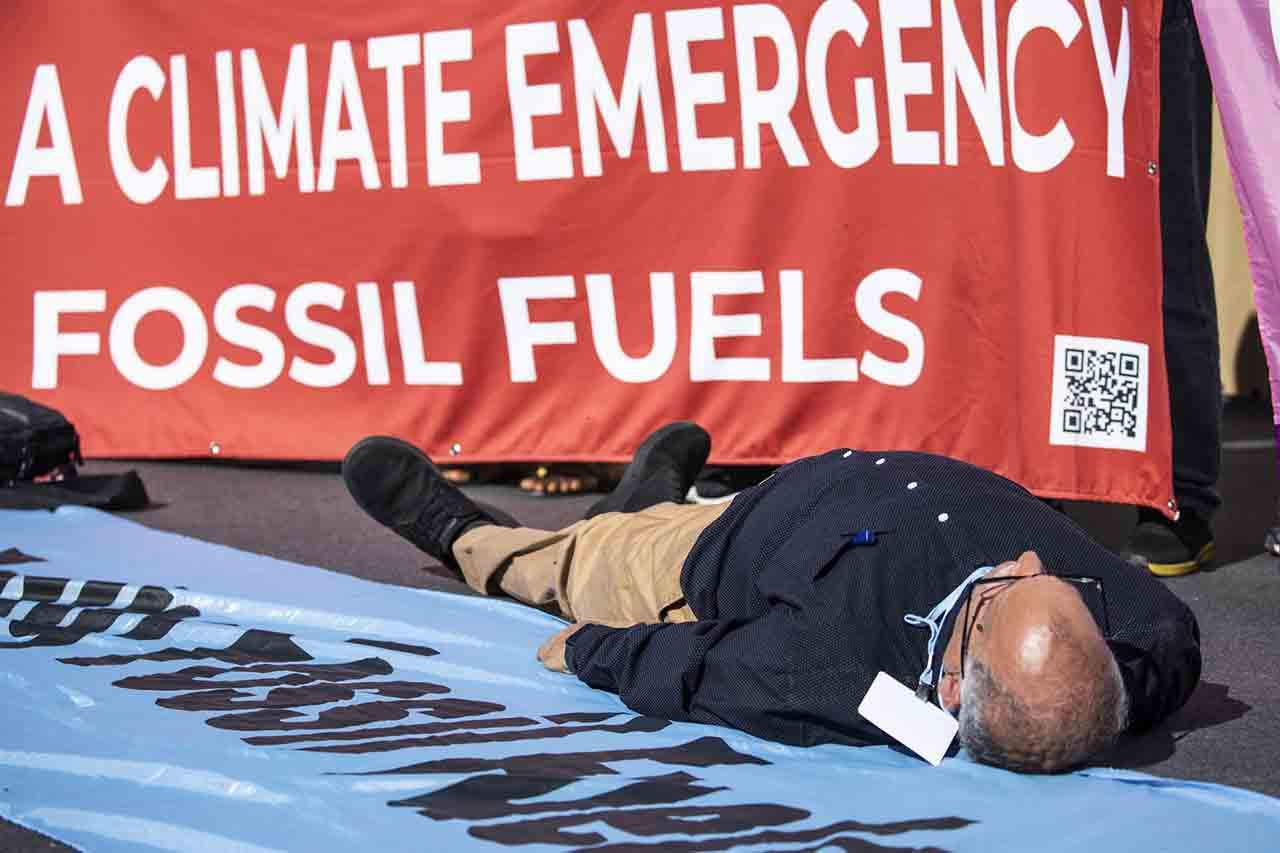 Activista climático tendido en el suelo durante una protesta contra los combustibles fósiles, en la COP27 de Sharm El Sheik / Foto: Gehad Hamdy