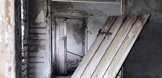 Una puerta cuelga de sus bisagras en un edificio agrícola abandonado en el centro de Estonia, en el antiguo emplazamiento de una gran granja colectiva de la época soviética / Foto: Capitán Swing