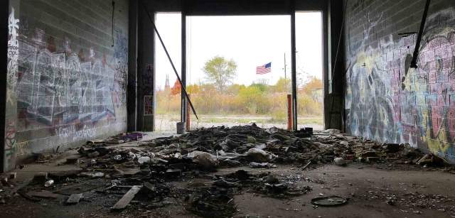 Las barras y estrellas ondean al viento, como se aprecia desde un almacén abandonado en Detroit (EE UU) / Foto: Capitán Swing