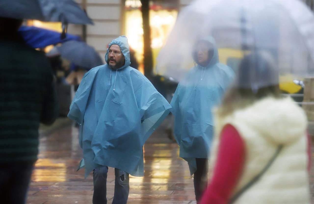 Varias personas se resguardan con paraguas. 35 provincias este lunes por los efectos de la borrasca Efraín / Foto: EP