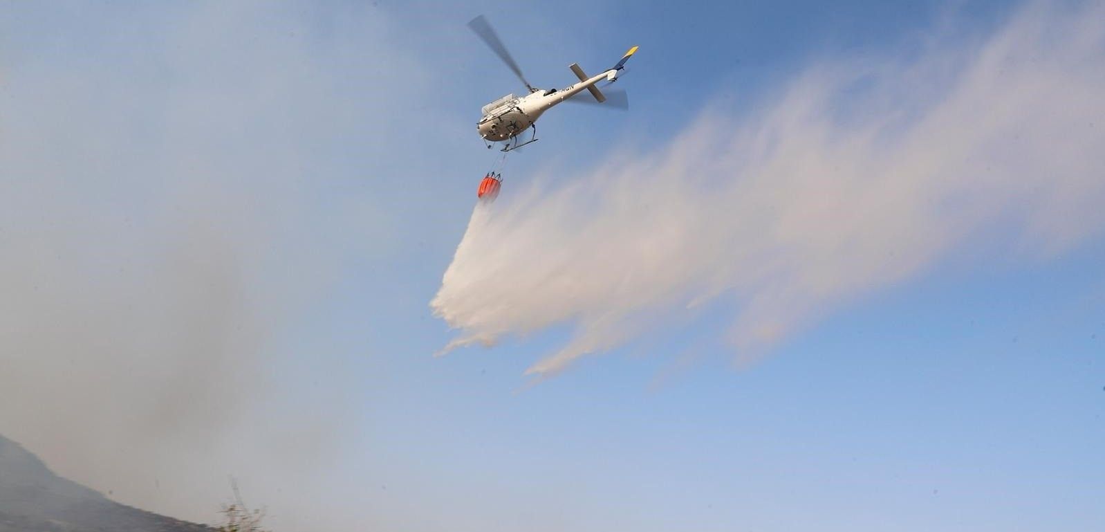 Un helicóptero descargando agua sobre las llamas en el siniestro de la Comunidad de Madrid / Foto: EP
