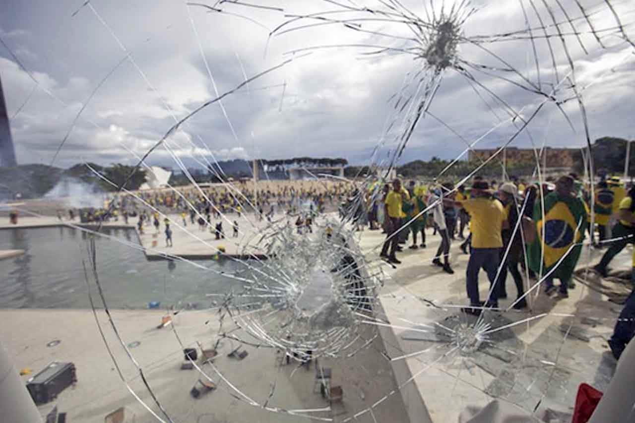 Simpatizantes del expresidente brasileño Jair Bolsonaro se enfrentan a las fuerzas de seguridad ante el ataque en las inmediaciones de la plaza de los Tres Poderes de Brasilia / The Conversation