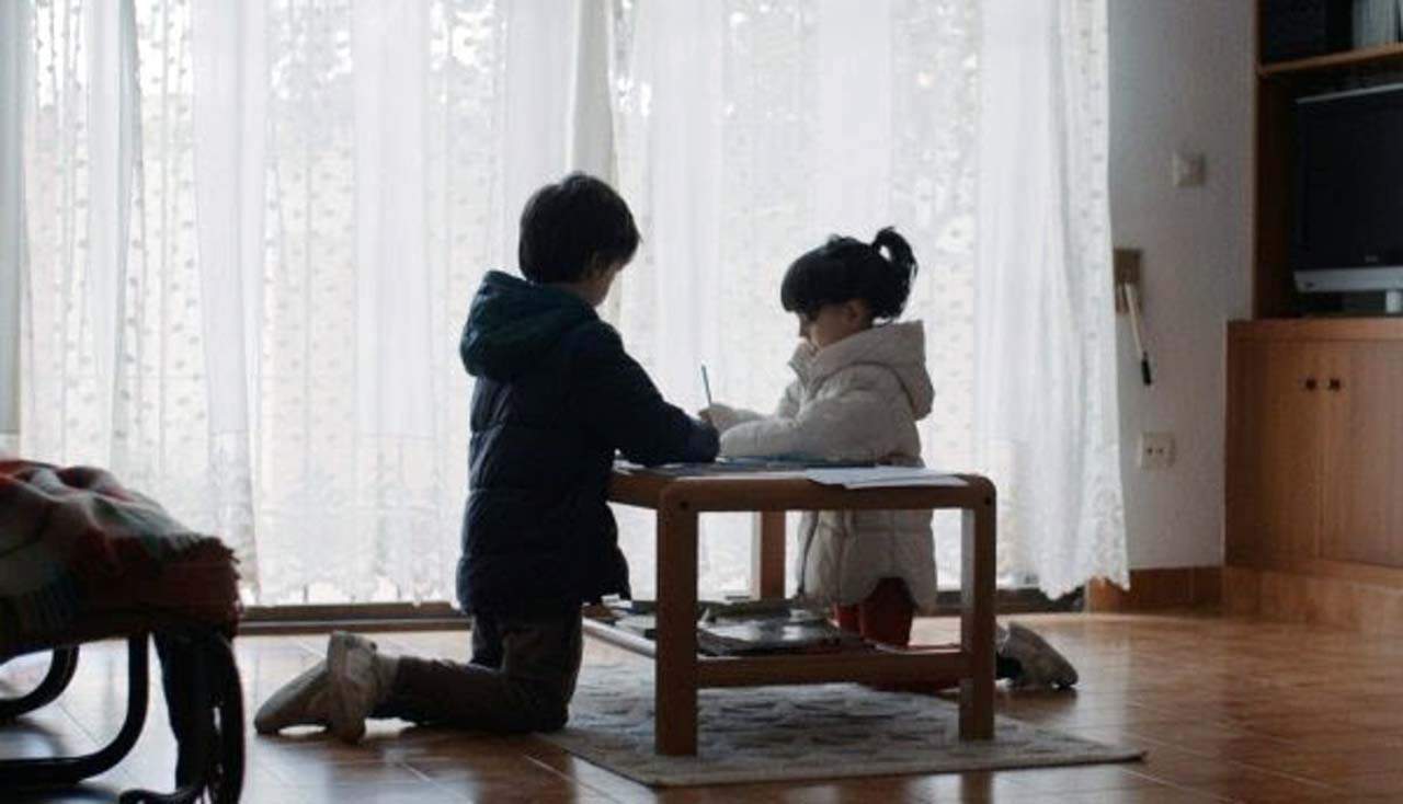 Una niña y un niño con abrigo en casa al carecer de recursos para mantener una temperatura adecuada en invierno. Pobreza energética / Foto: EP