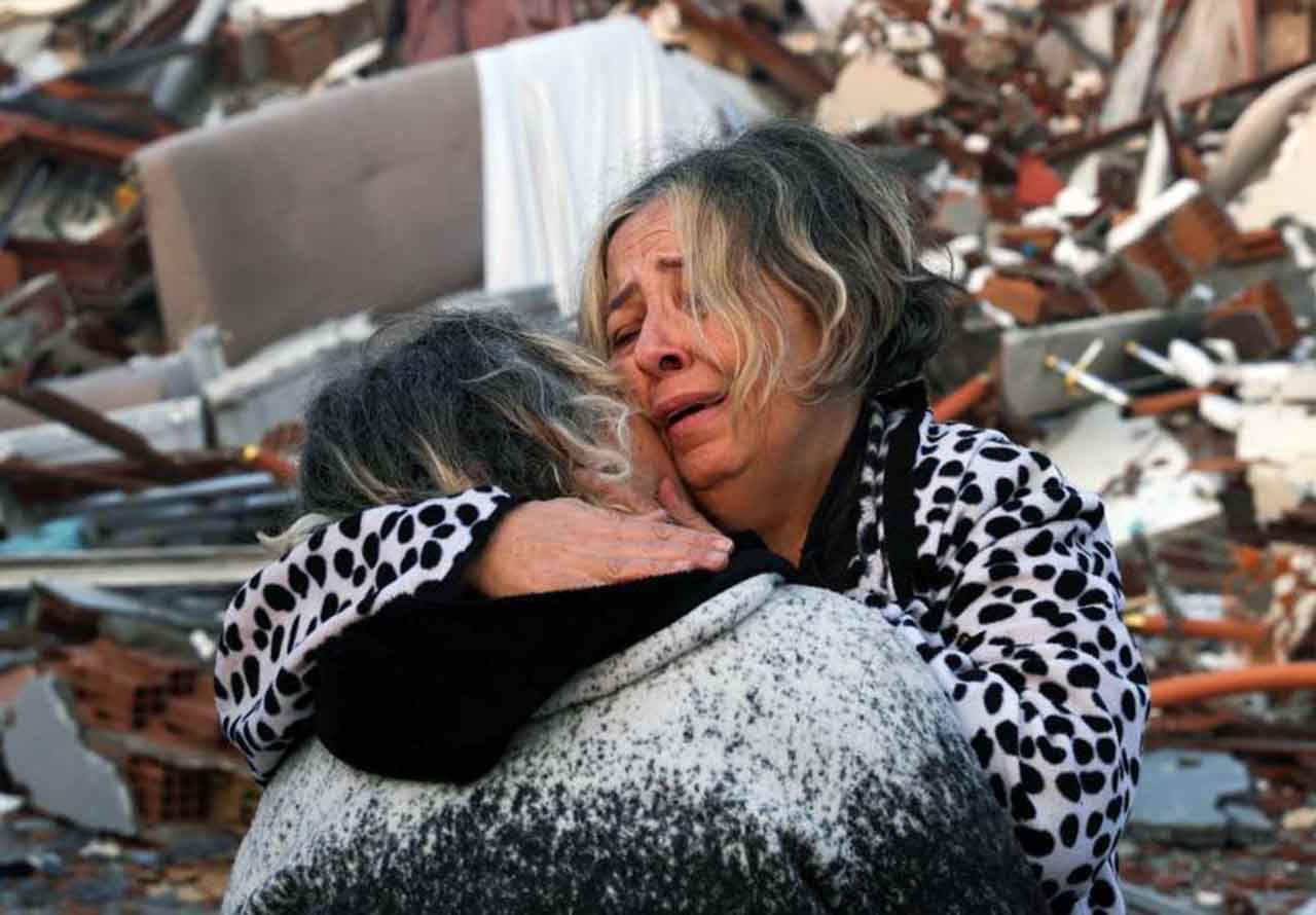 Dos mujeres se abrazan en medio de la destrucción del terremoto en Hatay, Turquía / Foto: Reuters - EP
