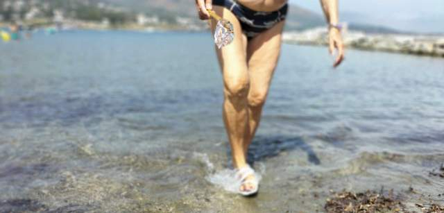 Una persona mayor recoge ejemplares de medusa de ‘Aequorea forskalea’ en la playa principal del Port de la Selva después de un episodio de plaga durante el verano de 2022. Son poco frecuentes en la zona, que normalmente se encuentra en aguas abiertas del Atlántico, Índico, Pacífico, pero también Mediterráneo / Foto: FFM - EA