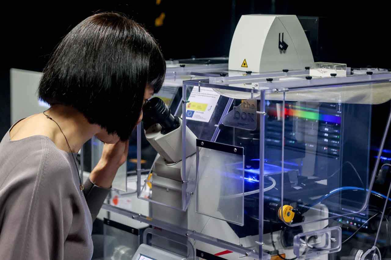 La ministra de Ciencia e Innovación, Diana Morant, mira por un microscopio en el Centro Nacional de Investigaciones Oncológicas (CNIO) / Foto: EP