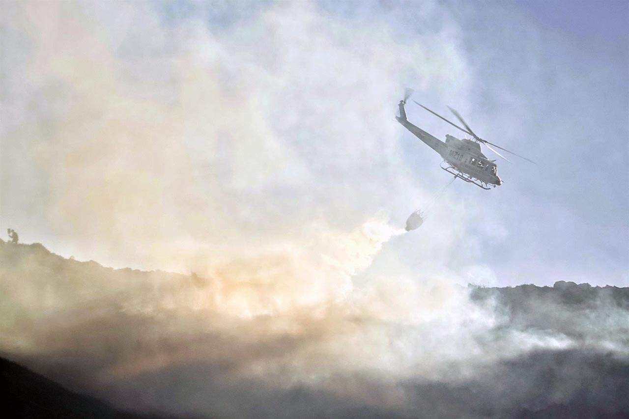 Un helicóptero de las Brigadas de Refuerzo en Incendios Forestales (BRIF) de Cantabria trabaja en las labores de extinción de un incendio forestal en el valle de Ardisana, a 10 de marzo de 2023, en Llano, Asturias (España) / Foto: EP