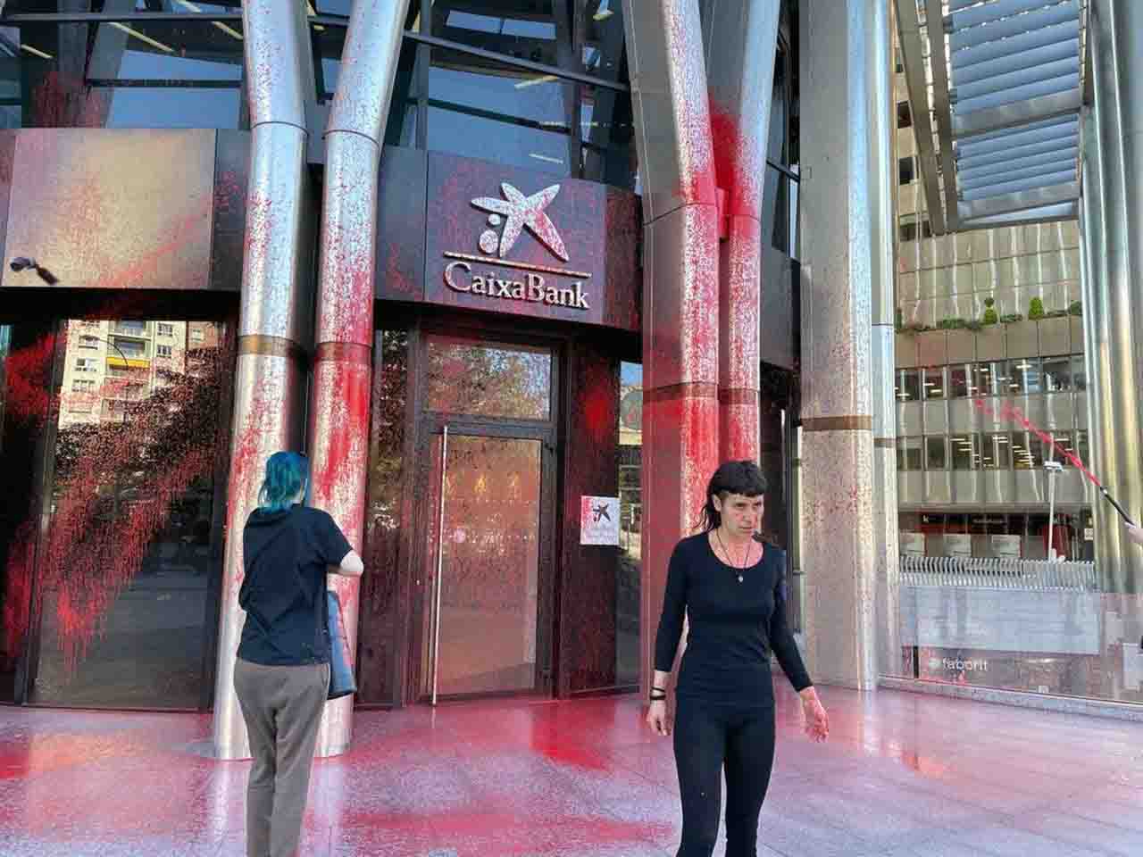 Dos activistas rocían de pintura roja y negra una sucursal de CaixaBank, en Madrid / Foto: FV