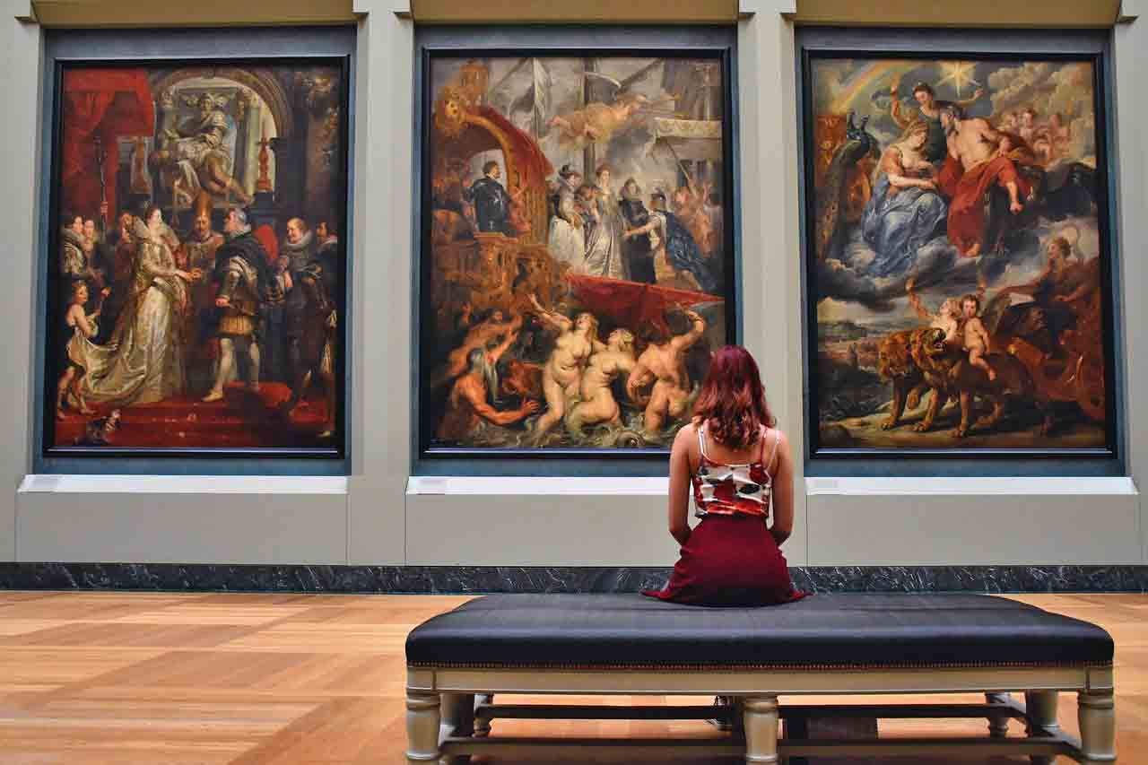 Una mujer contempla pinturas en un museo. El Día Internacional de los Museos
