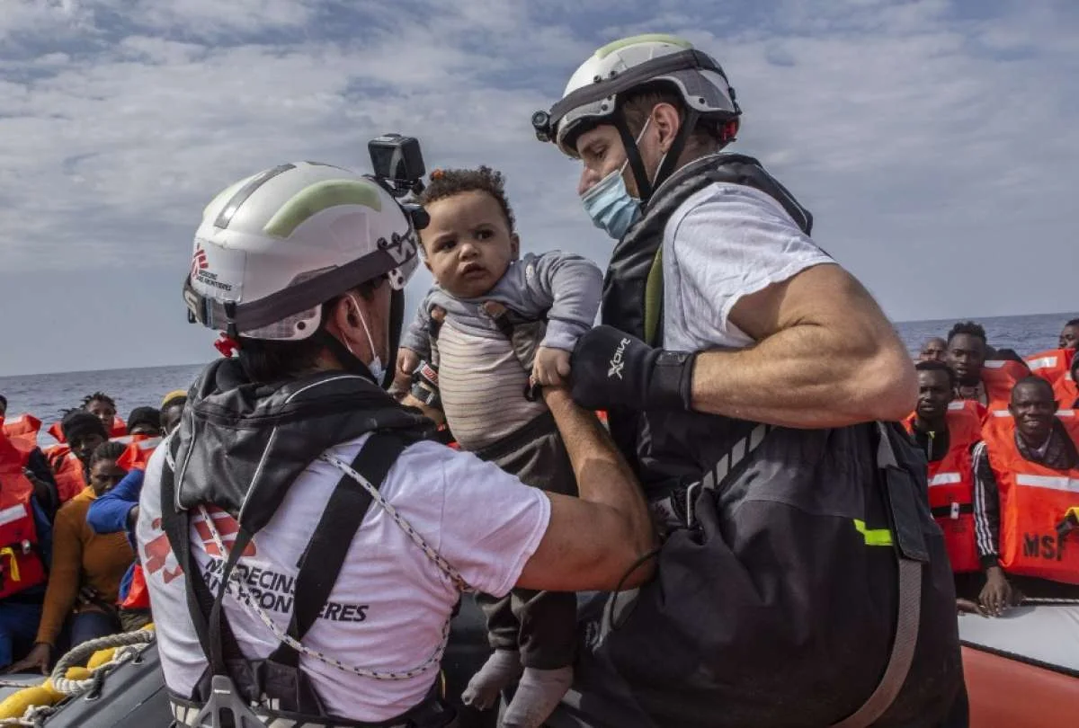 Un bebé es rescatado de un bote a punto de naufragar. Migrantes. Política migratoria / Foto: Médicos sin Fronteras