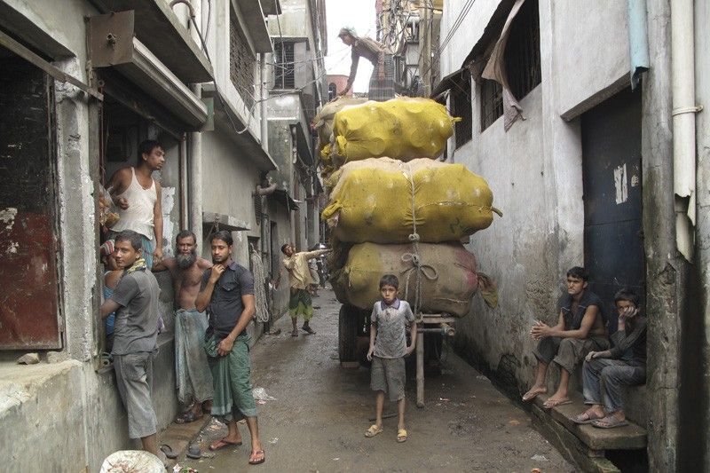 Un grupo de menores transporta un cargamento de cazuelas por las calles de la vieja Daca / Foto: Fundación Educo