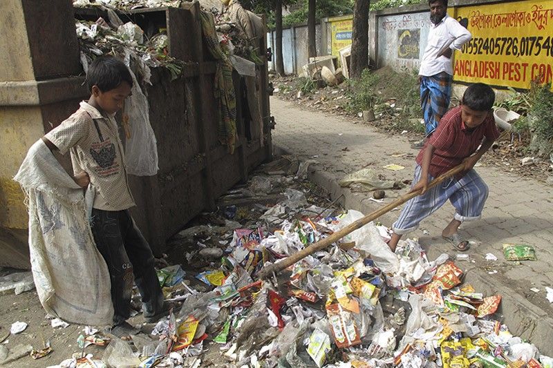 Niños no escolarizados buscan materiales reciclables entre la basura en las calles de la capital bengalí / Foto: Fundación Educo