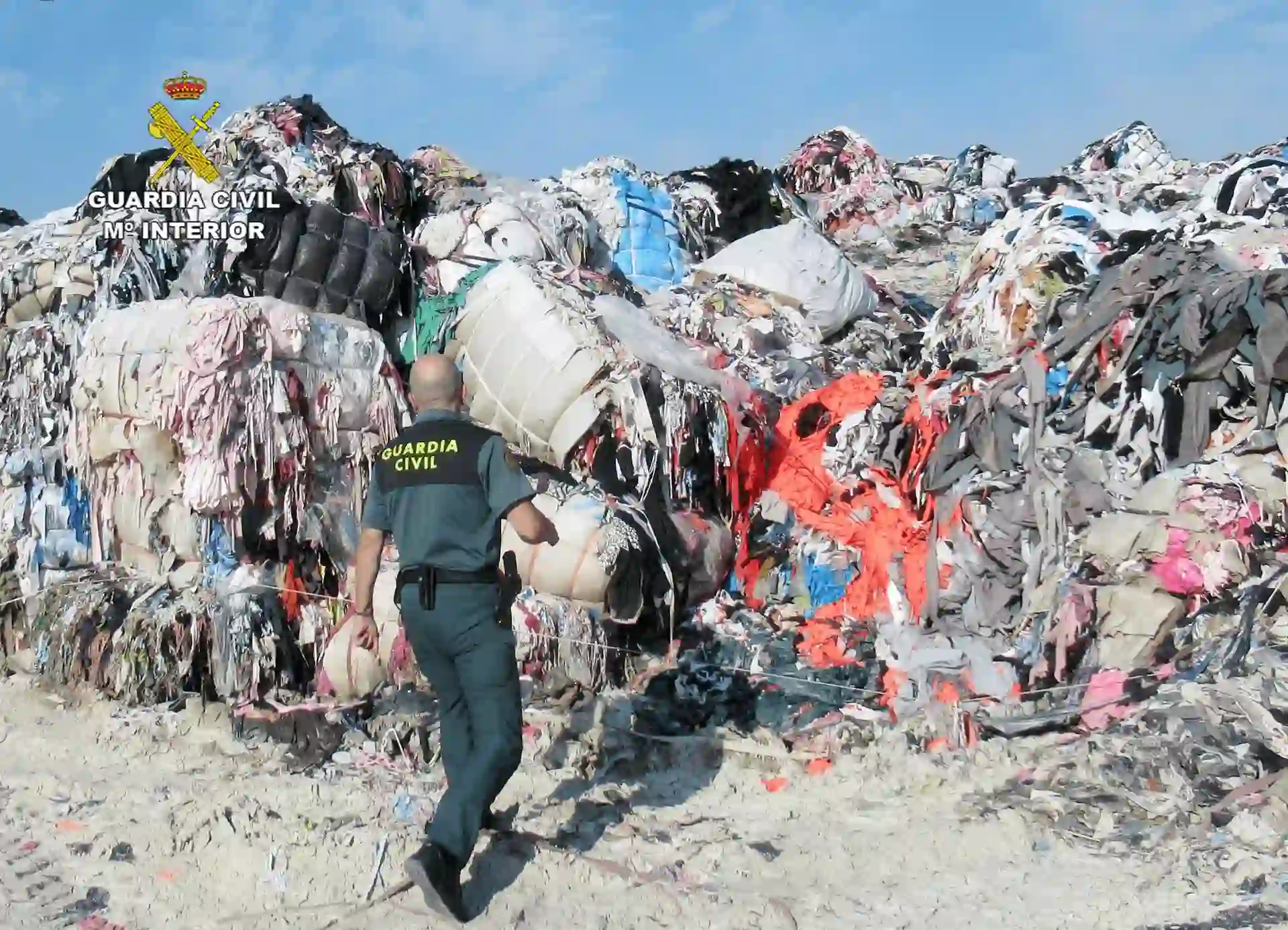 Un agente de la Guardia Civil junto a parte de los residuos textiles / Foto: Guardia Civil - EP