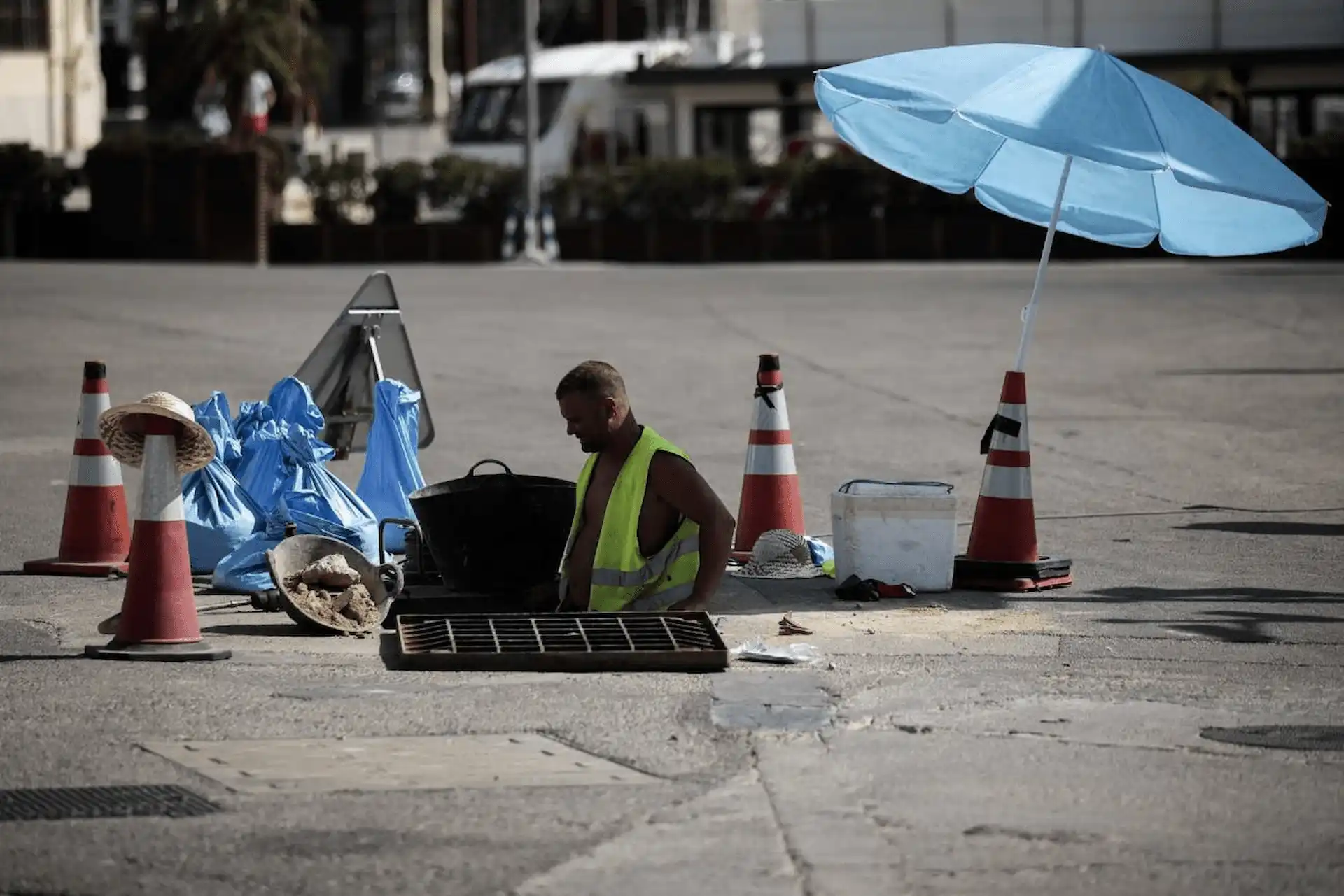 Un trabajador se protege del sol con una sombrilla en Valencia. El calor récord en 2022 provocó más de 61.000 muertes en Europa / Foto: SINC