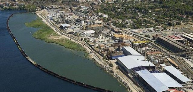 Vista aérea de la planta química de Ercros en Flix y la zona contaminada, aislada por un muro de protección / Foto: Acuamed