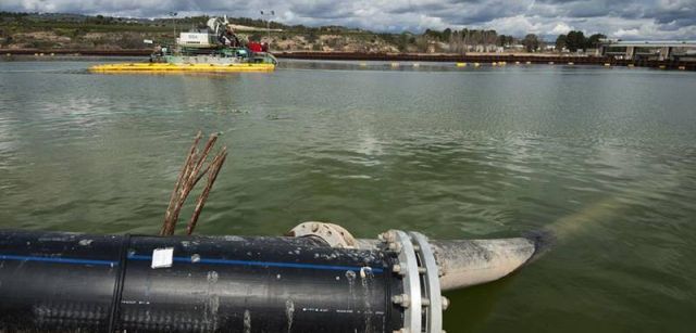 Una draga succiona los lodos contaminados del lecho del río, que son bombeados al exterior para su tratamiento / Foto: Josep Cano