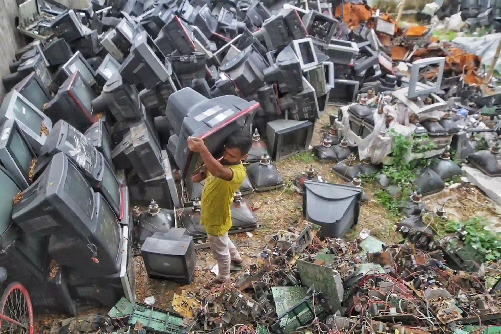 Una persona sujeta una televisión depositada como basura electrónica. Residuos electrónicos / Foto: Archivo - EP