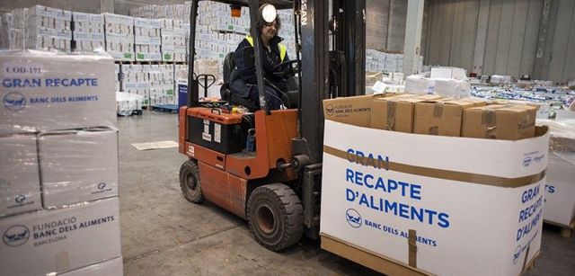 Una carretilla elevadora transporta paquetes de alimentos acabados de descargar / Foto: Josep Cano