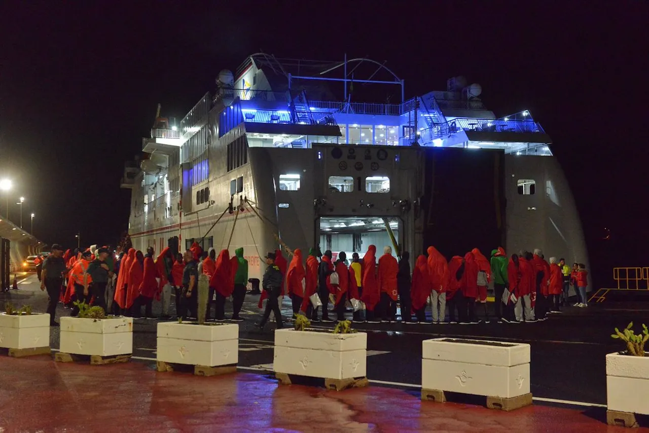 Decenas de migrantes hacen cola para entrar a un barco, en el muelle de La Restinga, a 22 de octubre de 2023 / Foto: EP