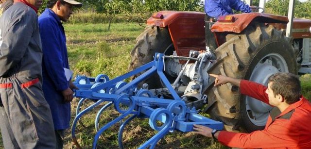 Un técnico voluntario de la ONG asesora a los nuevos usuarios de un tractor en Bolivia / Foto: BdR