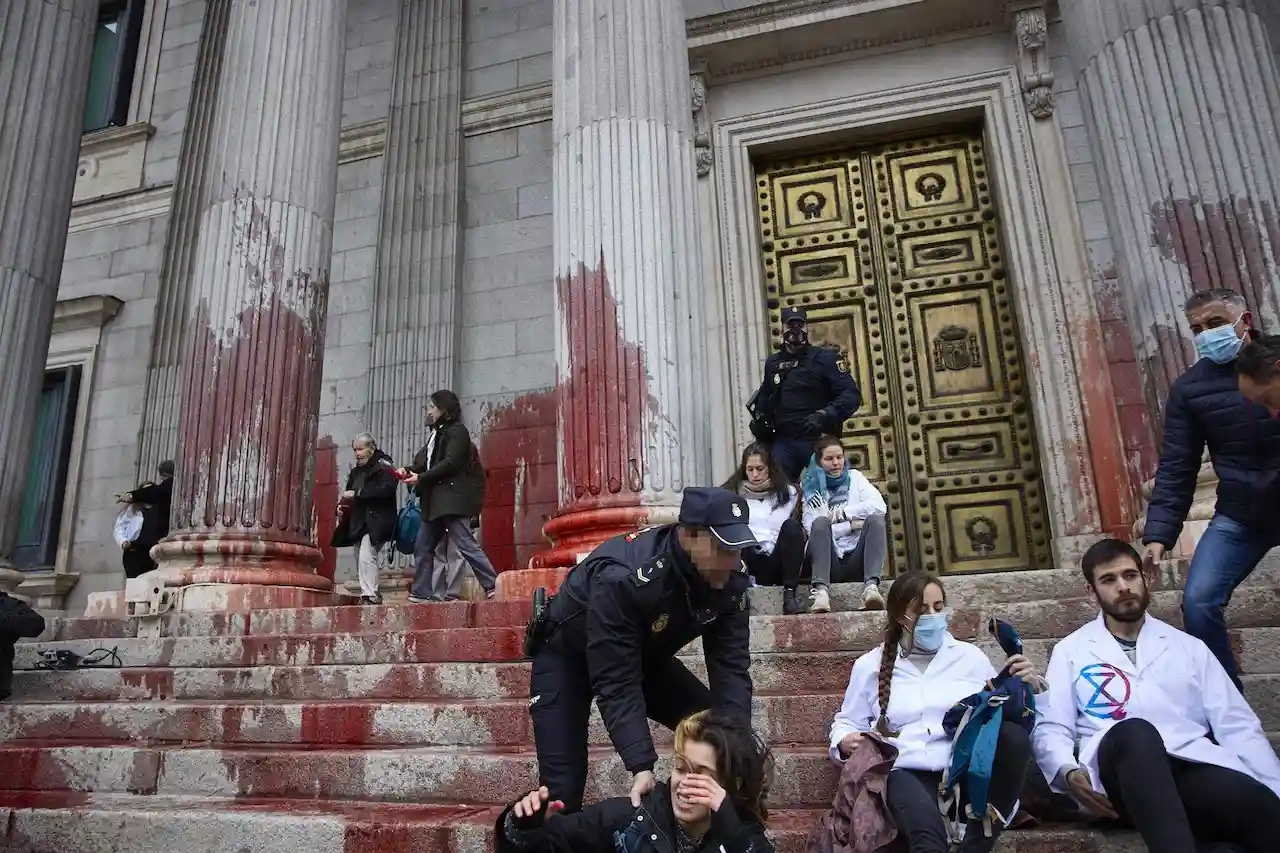 Científicos y científicas lanzan agua de remolacha en la fachada del Congreso / Foto: Jesús Hellín