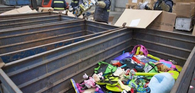 Trabajadores sacan de sus cajas juguetes averiados y rotos para su posterior reciclado / Foto: Josep Cano