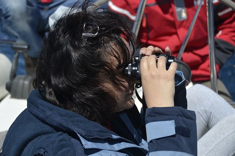 Una de las participantes en las salidas de Cetàcea escruta el mar con sus prismáticos / Foto: Associació Cetàcea