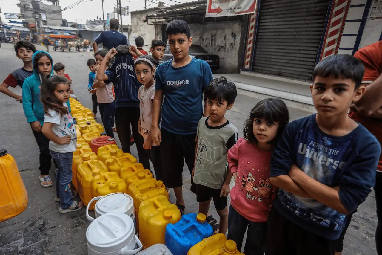 Niños palestinos hacen cola en Rafá para poder llenar bidones con agua potable / Foto: EP
