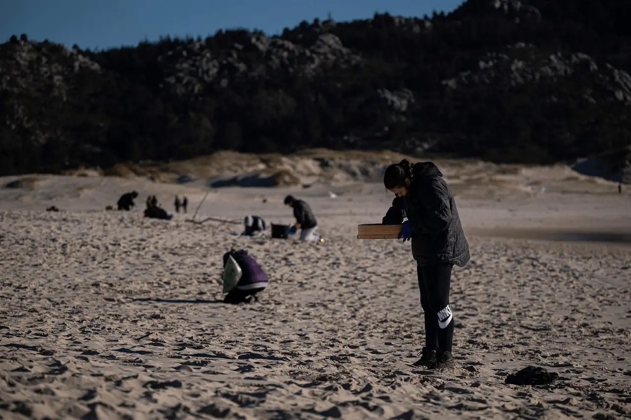 Voluntarios participan en la recogida de pellets de plástico en una playa de Muros (A Coruña) / Foto: EP