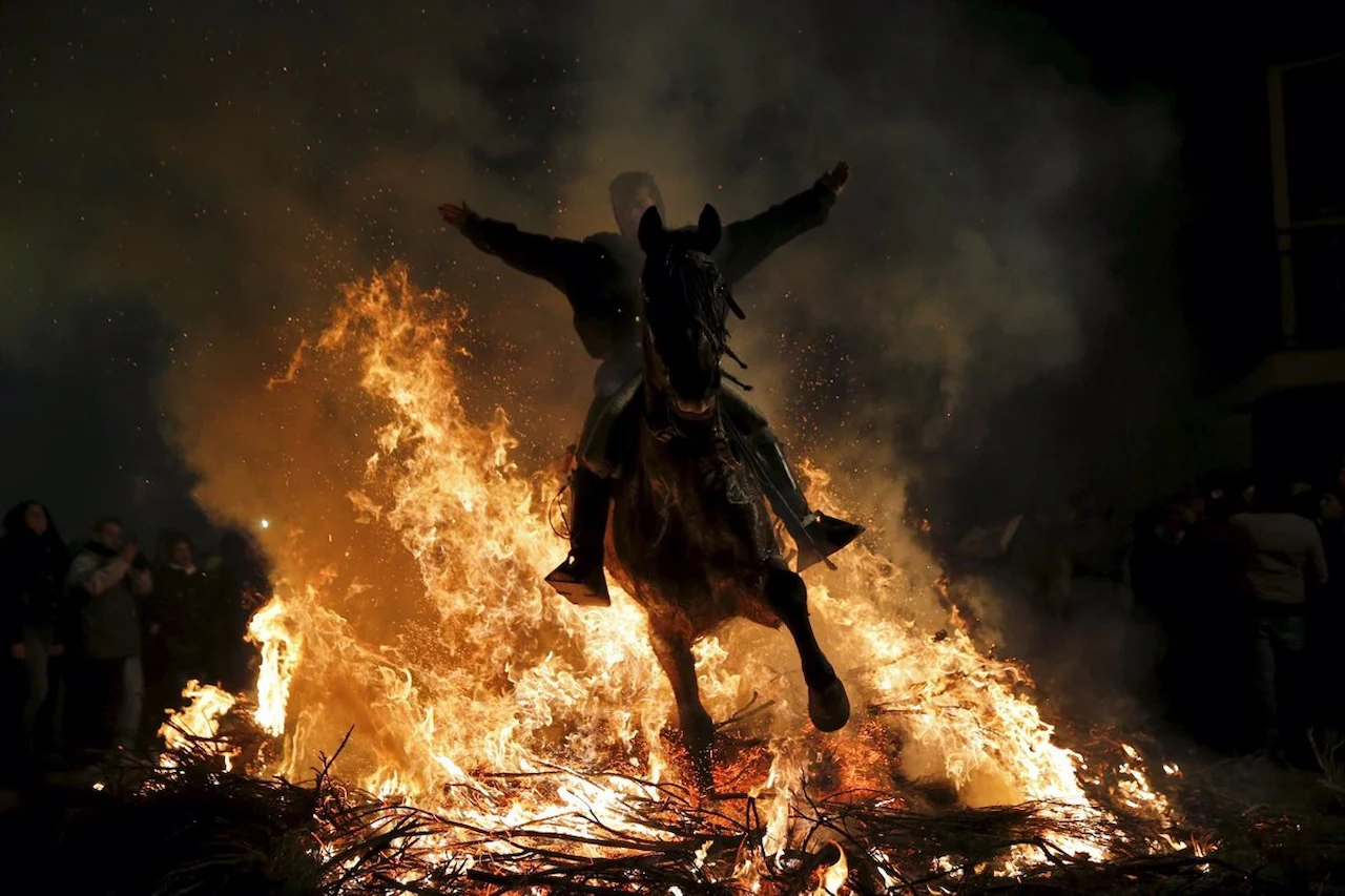 Un jinete y un caballo atraviesan el fuego de una hoguera en las fiestas de las Luminarias / Foto: EP