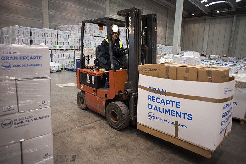 Una carretilla elevadora transporta paquetes de alimentos acabados de descargar / Foto: Josep Cano