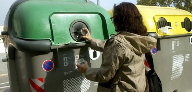 Una ciudadana deposita envases de vidrio en un contenedor verde de Barcelona / Foto: CF