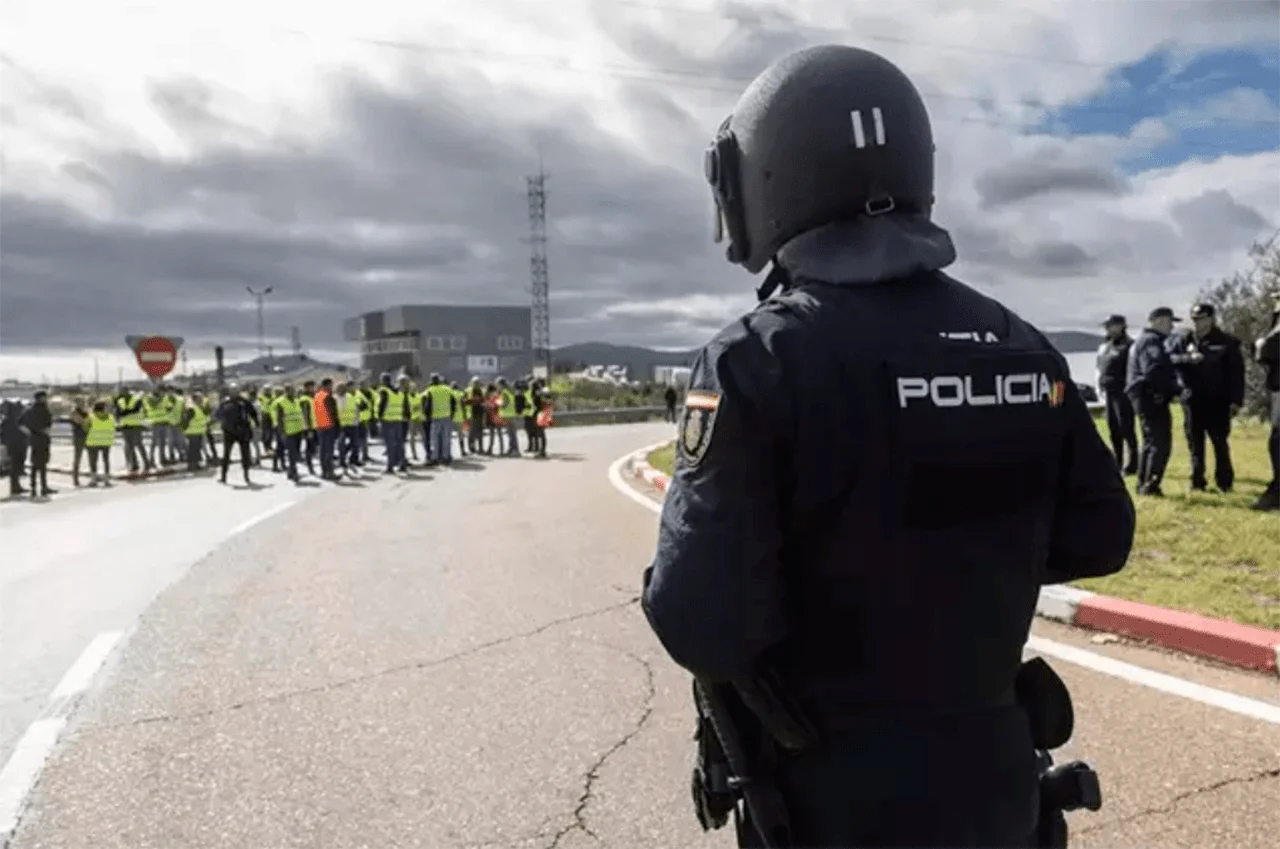 Un agente de Policía Nacional frente a agricultores en la rotonda de Agricultura de Mérida que conecta la A 5 con la nacional 630 / Foto: EP