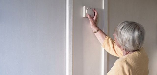 Una mujer ajusta el termostato de la calefacción / Foto: T. Bradford