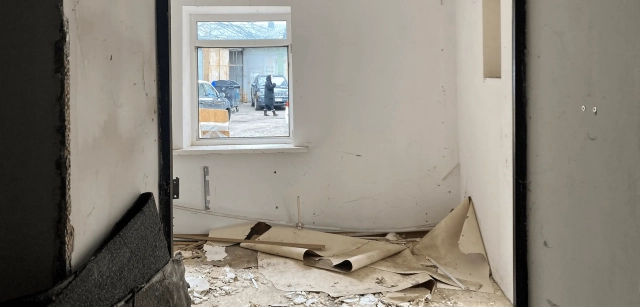 Vista al exterior de una mujer a través de una ventana de una casa que fue bombardeada por las tropas rusas en el centro de Kiev (Ucrania) / Foto: AG - EA