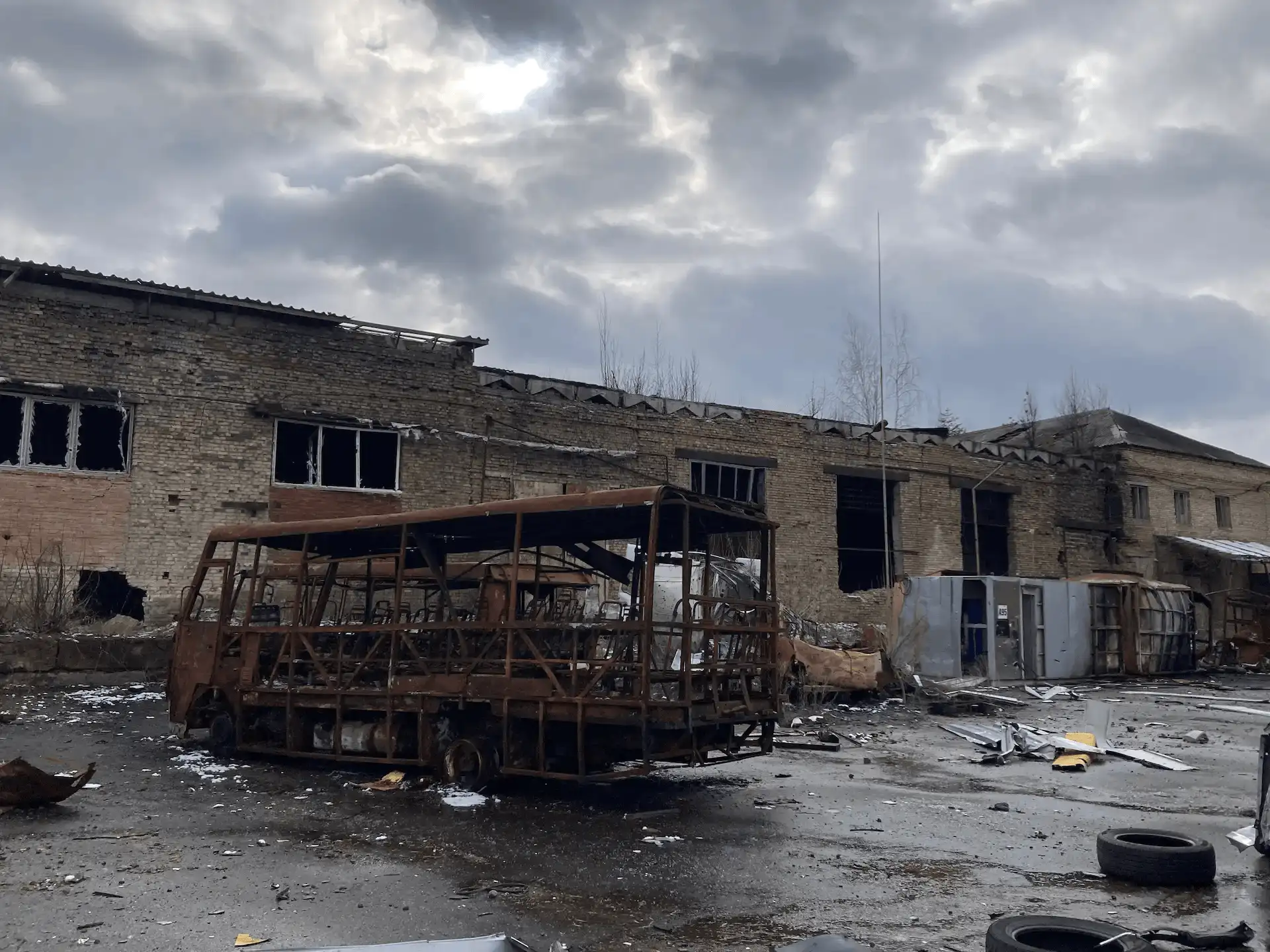 Estructura calcinada de un vehículo de transporte colectivo, detrás las ruinas de un edificio destruido a causa de la explosión de una bomba en Irpin en el noreste de Ucrania / Foto: AG - EA