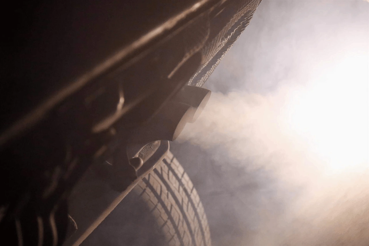 Tubo de escape de un coche emitiendo polución. Contaminación del aire