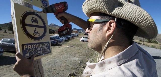 Un integrante del 'batallón' coloca un letrero prohibiendo el paso de vehículos en una zona protegida / Foto: Batallón Basurista