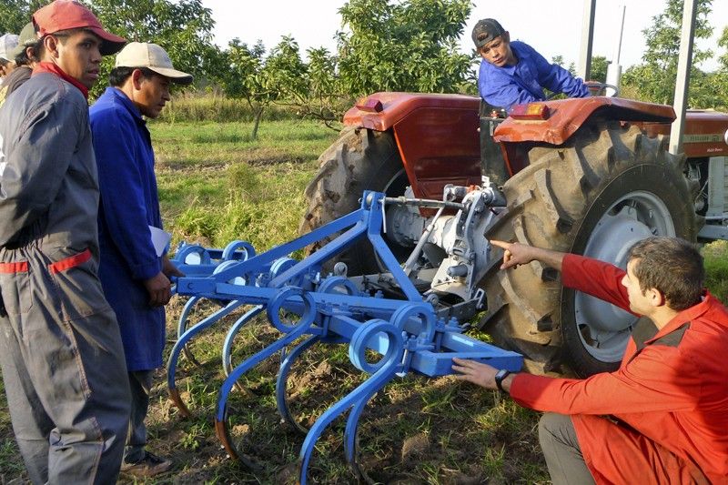 Un técnico voluntario de la ONG asesora a los nuevos usuarios de un tractor en Bolivia / Foto: BdR