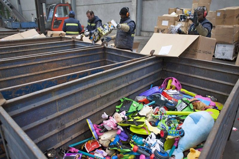 Trabajadores sacan de sus cajas juguetes averiados y rotos para su posterior reciclado / Foto: Josep Cano