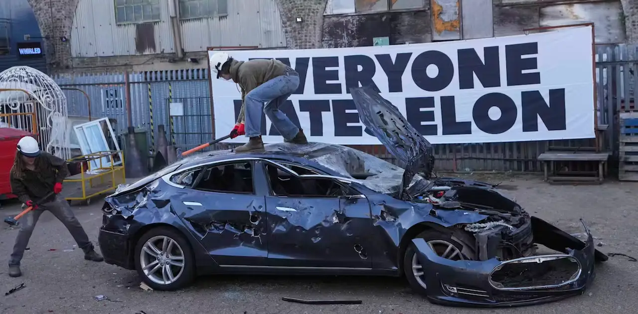 Sin regulación, las plataformas digitales amplían los conflictos. Manifestantes destruyen un coche de Tesla, la marca de coches eléctricos del magnate Elon Musk, también propietario de la red social X, asesor del Gobierno de Trump / The Conversation
