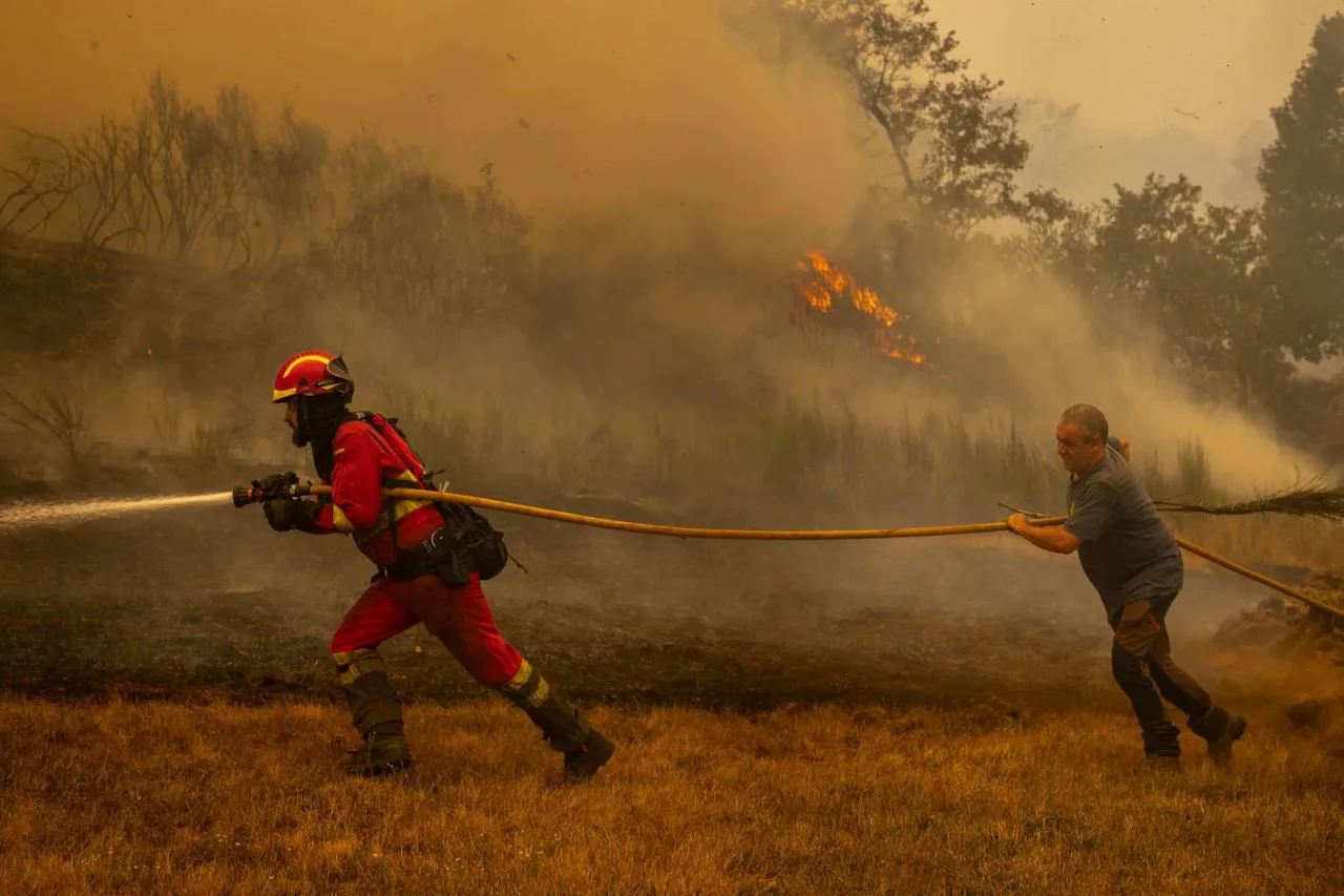 Un efectivo de la UME y un vecino de la localidad de A Espasa trabajan durante el incendio forestal. Incendios forestales / Foto: EFE-Brais Lorenzo