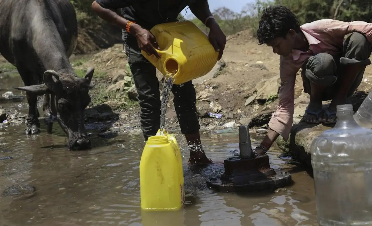 La falta de acción climática se cobra millones de vidas cada año. Dos hombres rellenan garrafas con agua potable procedente de una tubería rota en Bombay (India) / Foto:  EFE/Divyakant Solanki La falta de acción climática se cobra millones de vidas cada año. Dos hombres rellenan garrafas con agua potable procedente de una tubería rota en Bombay (India) / Foto:  EFE/Divyakant Solanki