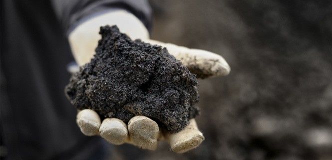 Un puñado de la mezcla de arena, arcilla, agua y bitumen de los yacimientos de Alberta, Canadá / Foto: Francis Black