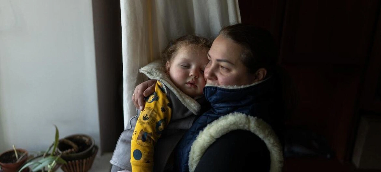 Madre ucraniana abraza a su hija obrigadas a llevar abrigo en casa / Foto: ONU