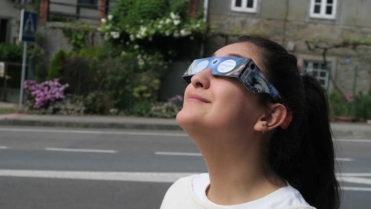 Una joven observa el cielo con gafas homologadas para eclipse solar, recomendadas para proteger la vista durante el fenómeno astronómico / Foto: EP